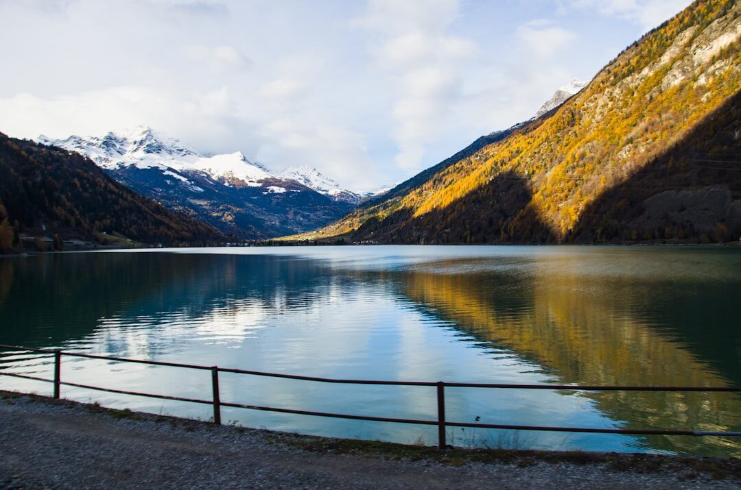 Panoramic view of a turquoise Swiss lake surrounded by mountains at golden hour